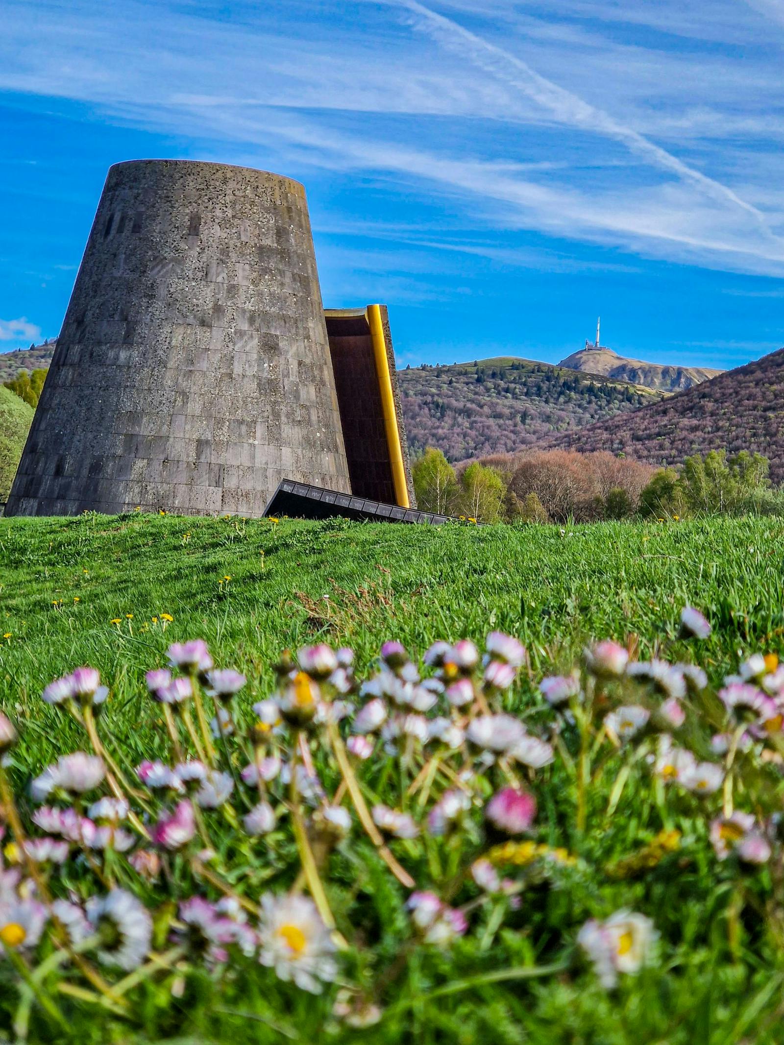 Nedre utsyn av Vulcania-monumentet med blomster i forgrunnen
